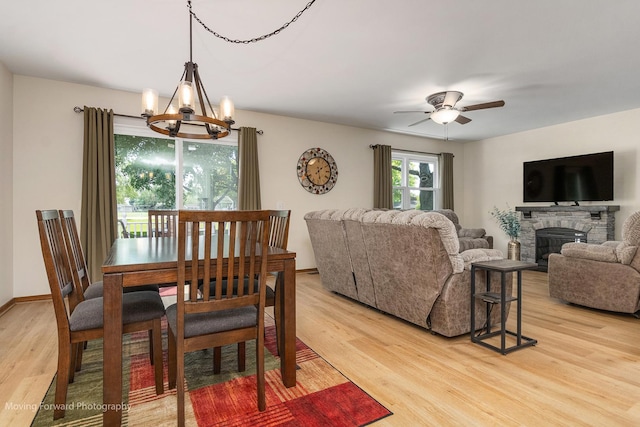 150 Meadows Ct, Sugar Grove, IL 60554 - dining space with a chandelier, light wood-style flooring, a fireplace, and a ceiling fan