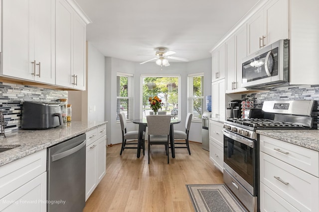150 Meadows Ct, Sugar Grove, IL 60554 - kitchen with stainless steel appliances, a ceiling fan, backsplash, light wood finished floors, and white cabinets