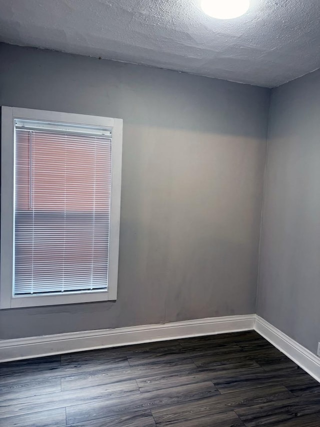 6529 S Laflin St, Chicago, IL 60636 - empty room with dark wood-style flooring, baseboards, and a textured ceiling