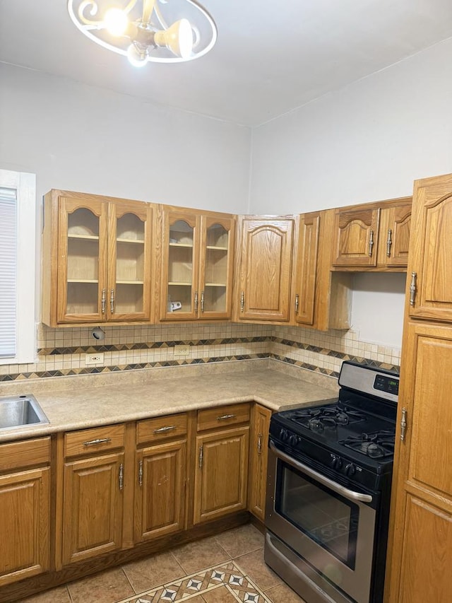 6529 S Laflin St, Chicago, IL 60636 - kitchen with stainless steel gas stove, light tile patterned floors, decorative backsplash, and light countertops