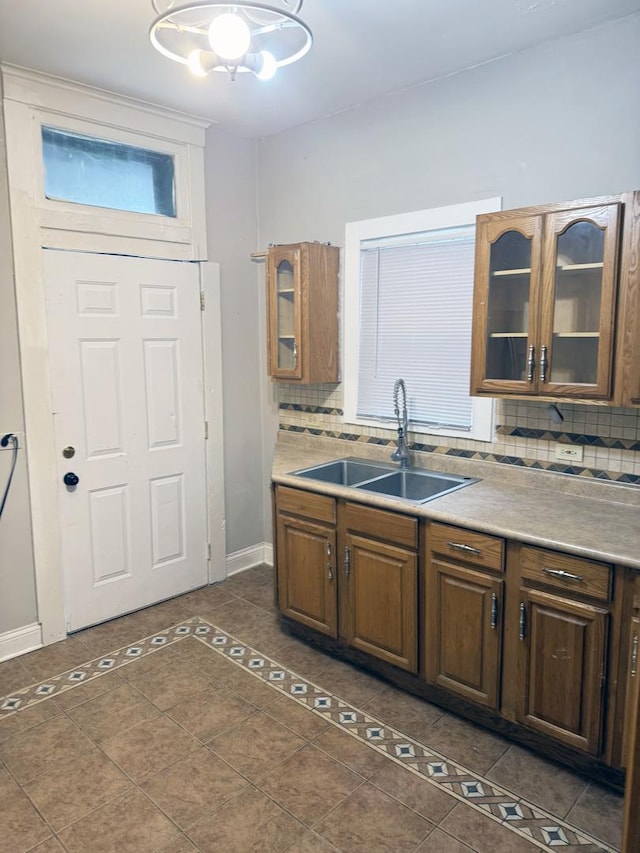 6529 S Laflin St, Chicago, IL 60636 - kitchen with a sink, dark tile patterned flooring, a chandelier, tasteful backsplash, and baseboards