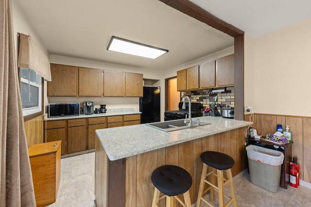 15424 David Ln, Oak Forest, IL 60452 - kitchen with freestanding refrigerator, stainless steel microwave, a peninsula, wainscoting, and a kitchen breakfast bar