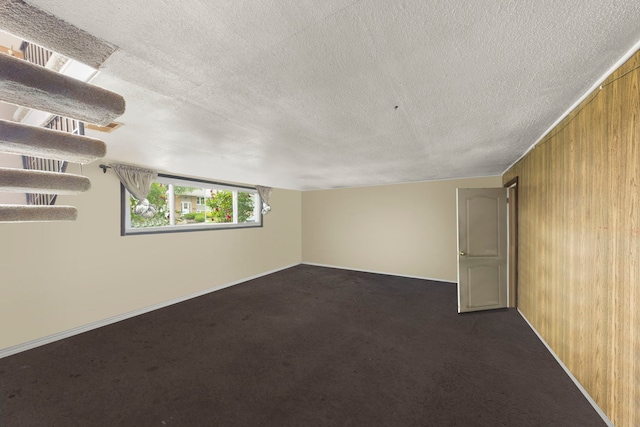 15424 David Ln, Oak Forest, IL 60452 - spare room with wooden walls, a textured ceiling, and dark colored carpet
