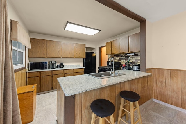 15424 David Ln, Oak Forest, IL 60452 - kitchen featuring freestanding refrigerator, stainless steel microwave, a peninsula, wood walls, and a wainscoted wall