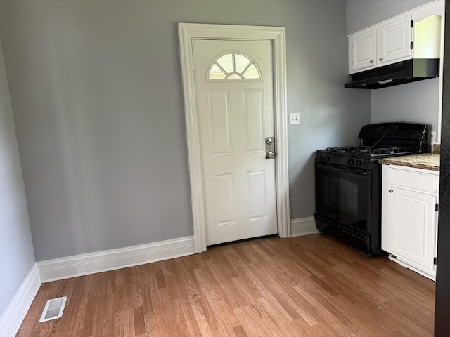 509 S May St, Joliet, IL 60436 - kitchen featuring black gas range, under cabinet range hood, light wood-type flooring, and baseboards