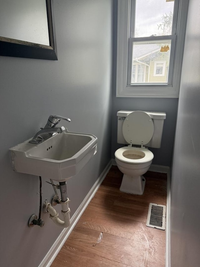 509 S May St, Joliet, IL 60436 - half bath featuring wood finished floors, toilet, and baseboards