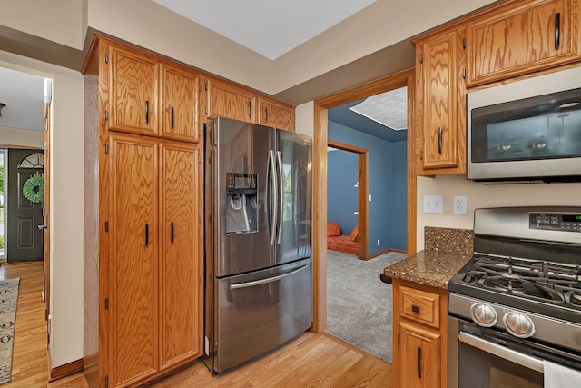 605 Feeney Dr, Minooka, IL 60447 - kitchen with appliances with stainless steel finishes, light wood-style flooring, dark stone countertops, and brown cabinetry