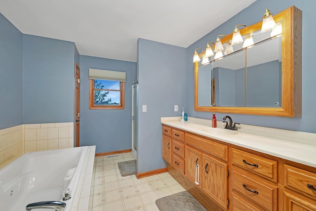 605 Feeney Dr, Minooka, IL 60447 - bathroom featuring vanity, a whirlpool tub, tile patterned floors, a stall shower, and baseboards
