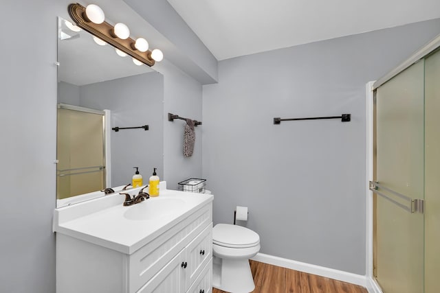 605 Feeney Dr, Minooka, IL 60447 - bathroom featuring a shower stall, vanity, wood finished floors, toilet, and baseboards