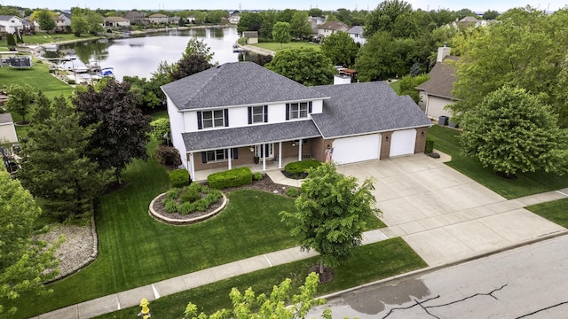 605 Feeney Dr, Minooka, IL 60447 - view of front of home featuring covered porch, a shingled roof, an attached garage, a water view, and concrete driveway