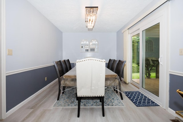 203 S Hershey Rd, Bloomington, IL 61704 - dining area with wood finished floors, a chandelier, and baseboards