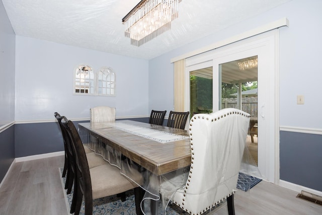 203 S Hershey Rd, Bloomington, IL 61704 - dining room with wood finished floors, a chandelier, and baseboards