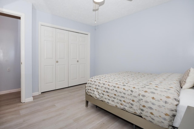 203 S Hershey Rd, Bloomington, IL 61704 - bedroom featuring light wood-style floors, a closet, baseboards, and ceiling fan