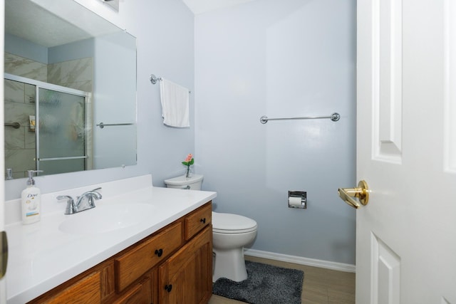 203 S Hershey Rd, Bloomington, IL 61704 - bathroom featuring toilet, vanity, a stall shower, and baseboards
