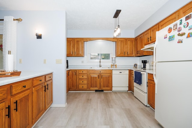 203 S Hershey Rd, Bloomington, IL 61704 - kitchen featuring white appliances, under cabinet range hood, a sink, light wood-style flooring, and brown cabinets