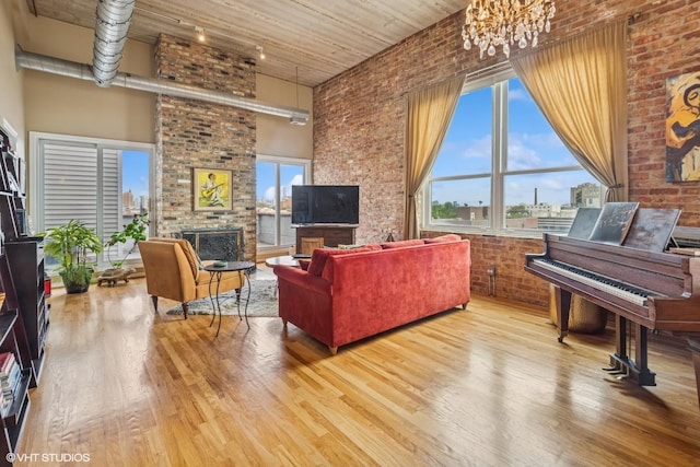 1625 N Western Unit 502, Chicago, IL 60647 - living area featuring wood finished floors, a fireplace, brick wall, a high ceiling, and a chandelier