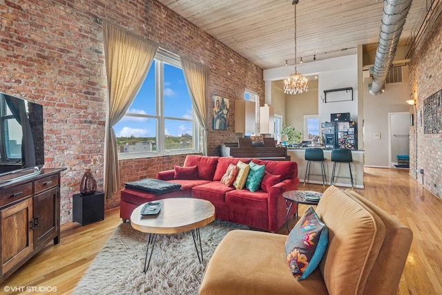 1625 N Western Unit 502, Chicago, IL 60647 - living area featuring brick wall, a chandelier, light wood-style floors, and a high ceiling