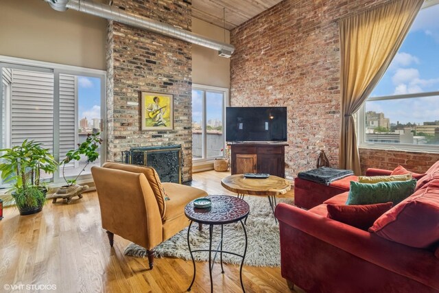 1625 N Western Unit 502, Chicago, IL 60647 - living room with a high ceiling, a brick fireplace, wood finished floors, and brick wall