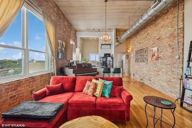 1625 N Western Unit 502, Chicago, IL 60647 - living area featuring brick wall, wood finished floors, plenty of natural light, a chandelier, and track lighting
