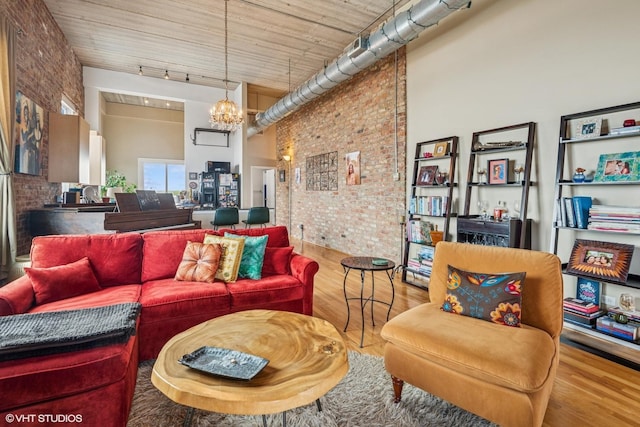 1625 N Western Unit 502, Chicago, IL 60647 - living room with a high ceiling, brick wall, a chandelier, wood finished floors, and track lighting
