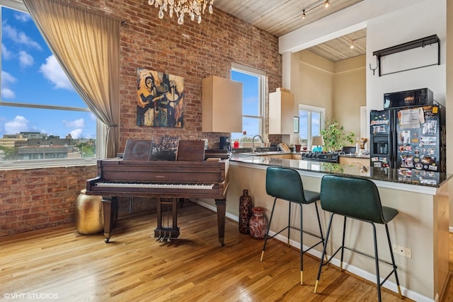 1625 N Western Unit 502, Chicago, IL 60647 - kitchen featuring black appliances, track lighting, wood finished floors, a kitchen bar, and a chandelier