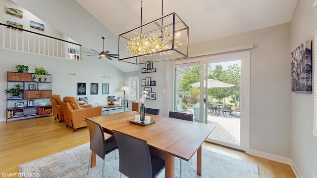 14352 Crystal Tree Dr, Orland Park, IL 60462 - dining area with light wood-style flooring, a ceiling fan, a chandelier, high vaulted ceiling, and baseboards