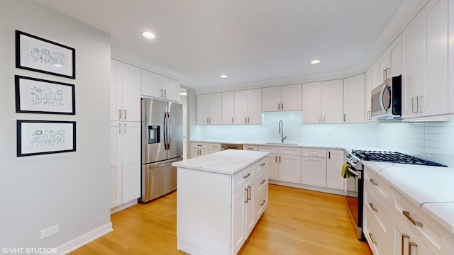 14352 Crystal Tree Dr, Orland Park, IL 60462 - kitchen with appliances with stainless steel finishes, a sink, light wood-type flooring, decorative backsplash, and white cabinets
