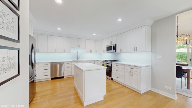 14352 Crystal Tree Dr, Orland Park, IL 60462 - kitchen with stainless steel appliances, a sink, light countertops, white cabinetry, and light wood-style floors