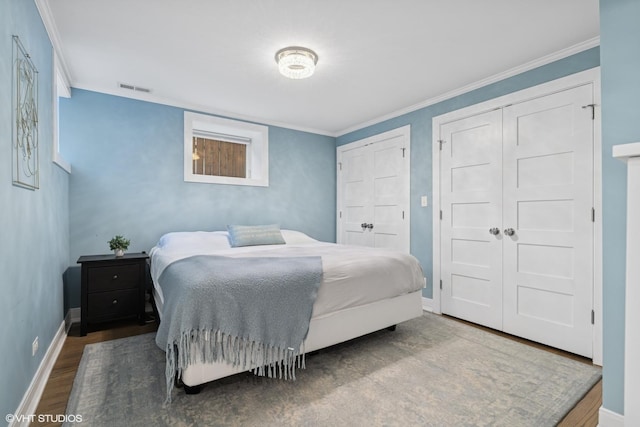 4428 N Racine Ave Unit Gn, Chicago, IL 60640 - bedroom featuring multiple closets, wood finished floors, baseboards, and crown molding