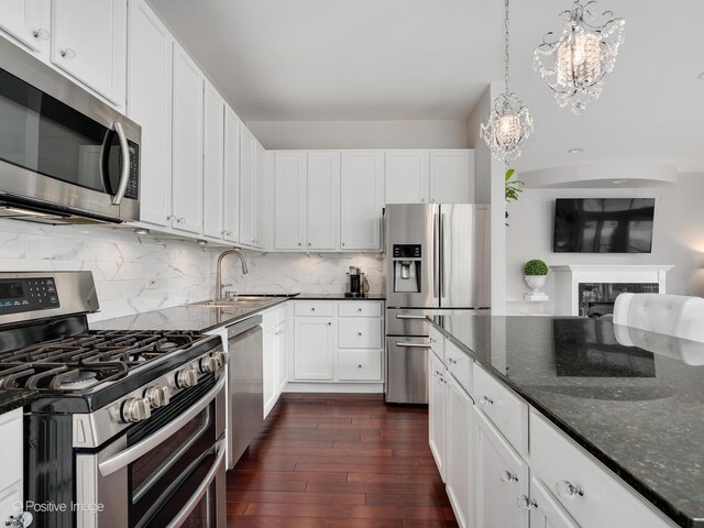 550 W Fulton St Unit 404, Chicago, IL 60661 - kitchen featuring stainless steel appliances, a chandelier, a sink, dark wood-type flooring, and dark stone countertops