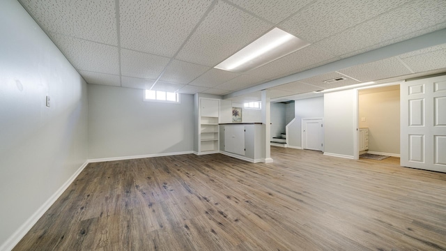 325 Goodrich St, Belvidere, IL 61008 - below grade area featuring a drop ceiling, stairs, wood finished floors, and baseboards