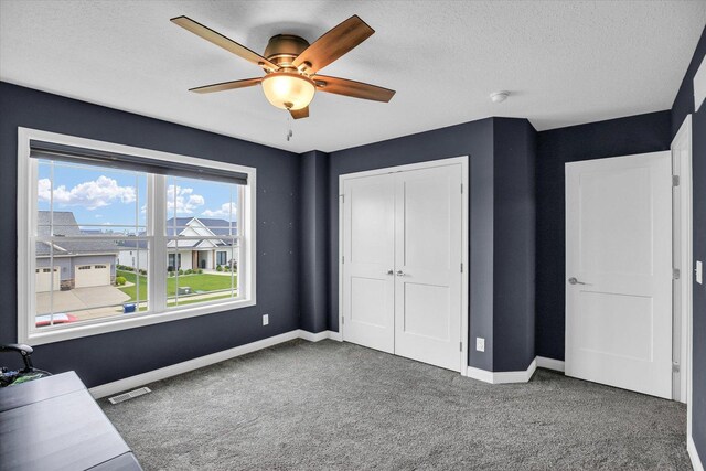1407 Winterberry Rd, Savoy, IL 61874 - unfurnished bedroom with carpet floors, a closet, a ceiling fan, and a textured ceiling