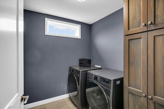 1407 Winterberry Rd, Savoy, IL 61874 - washroom featuring washer and dryer, cabinet space, a textured ceiling, and light tile patterned floors