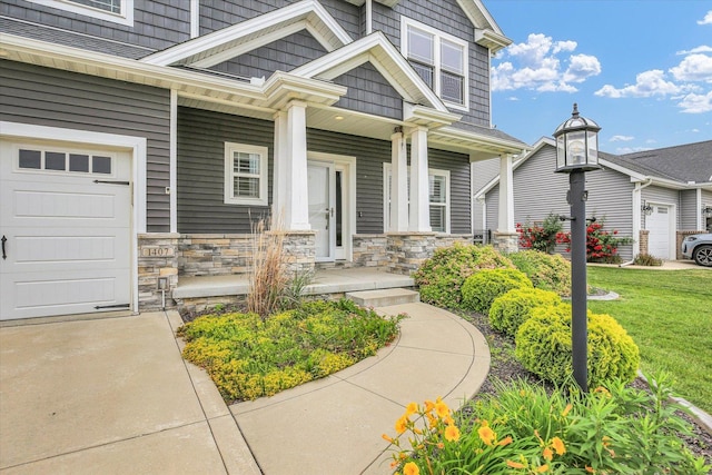 1407 Winterberry Rd, Savoy, IL 61874 - property entrance with a porch, stone siding, a garage, and a yard
