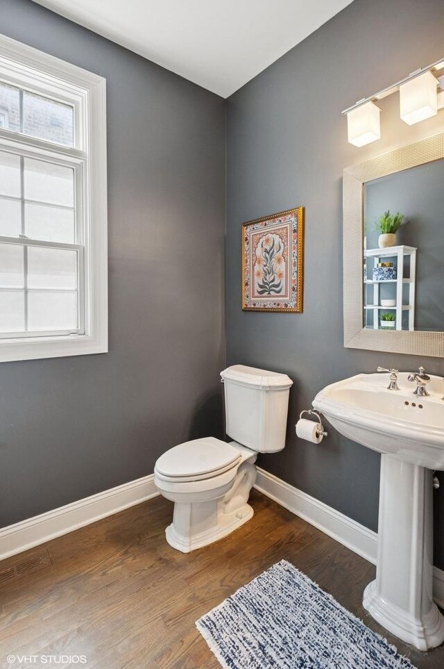 3414 N Bell Ave, Chicago, IL 60618 - half bath featuring toilet, wood finished floors, baseboards, and a sink