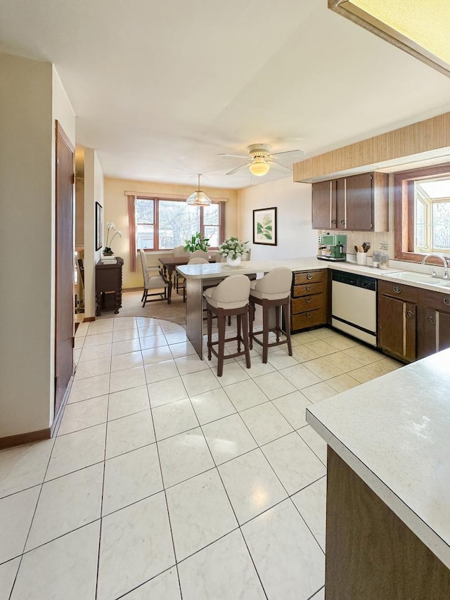 5431 S 7th Ave, Countryside, IL 60525 - kitchen with white dishwasher, a sink, a peninsula, light countertops, and ceiling fan