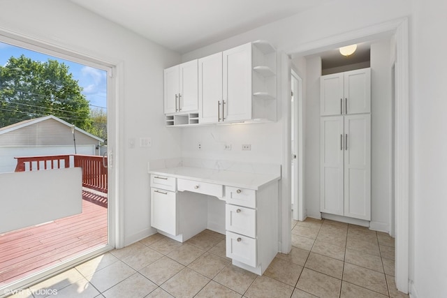 877 Hollywood Ave, Des Plaines, IL 60016 - kitchen with open shelves, light countertops, white cabinets, light tile patterned flooring, and a desk