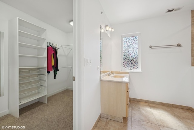 877 Hollywood Ave, Des Plaines, IL 60016 - full bathroom with vanity, baseboards, a walk in closet, and tile patterned flooring