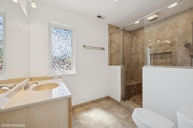 877 Hollywood Ave, Des Plaines, IL 60016 - bathroom featuring toilet, vanity, tile patterned floors, a stall shower, and baseboards