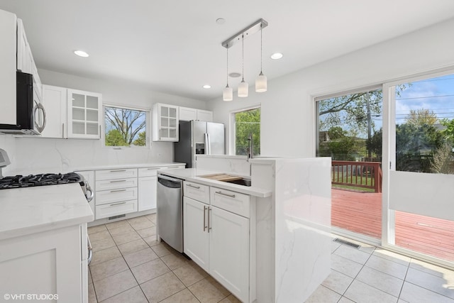 877 Hollywood Ave, Des Plaines, IL 60016 - kitchen with stainless steel appliances, healthy amount of natural light, light tile patterned flooring, glass insert cabinets, and recessed lighting