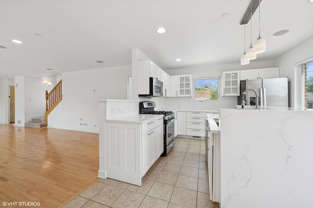 877 Hollywood Ave, Des Plaines, IL 60016 - kitchen featuring stainless steel appliances, glass insert cabinets, white cabinets, decorative light fixtures, and light tile patterned floors