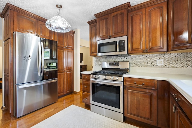 16203 Fox Ct, Orland Hills, IL 60487 - kitchen with stainless steel appliances, light wood-type flooring, backsplash, light countertops, and a textured ceiling