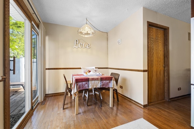 16203 Fox Ct, Orland Hills, IL 60487 - dining room featuring hardwood / wood-style flooring, a textured ceiling, baseboards, and a chandelier