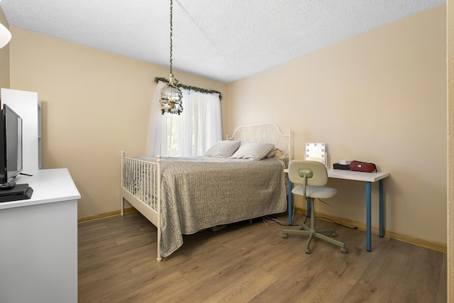 16203 Fox Ct, Orland Hills, IL 60487 - bedroom with wood finished floors, a textured ceiling, and baseboards