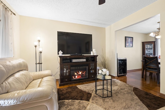 16203 Fox Ct, Orland Hills, IL 60487 - living area with wood finished floors, a textured ceiling, a chandelier, a glass covered fireplace, and baseboards