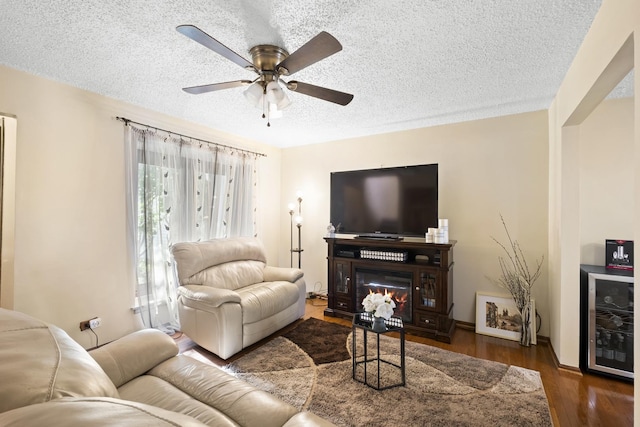 16203 Fox Ct, Orland Hills, IL 60487 - living room featuring wine cooler, a textured ceiling, wood finished floors, ceiling fan, and a glass covered fireplace
