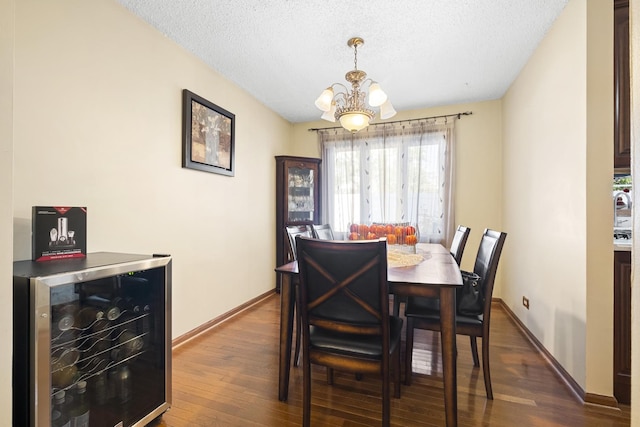 16203 Fox Ct, Orland Hills, IL 60487 - dining area featuring beverage cooler, a chandelier, dark wood-style floors, a textured ceiling, and baseboards