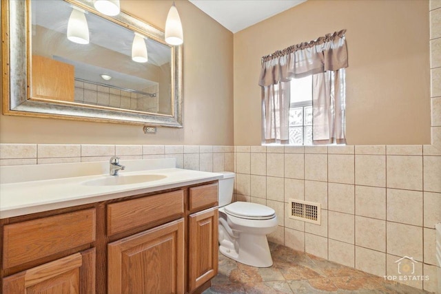 9258 Clancy Dr, Des Plaines, IL 60016 - bathroom featuring tile walls, vanity, toilet, and wainscoting