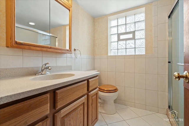 9258 Clancy Dr, Des Plaines, IL 60016 - bathroom featuring tile walls, vanity, toilet, a stall shower, and tile patterned flooring