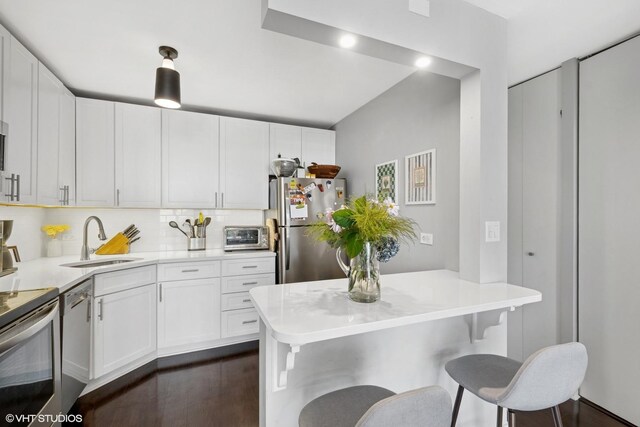 1636 N Wells St Unit 1107, Chicago, IL 60614 - kitchen featuring appliances with stainless steel finishes, a sink, a breakfast bar, white cabinetry, and light countertops